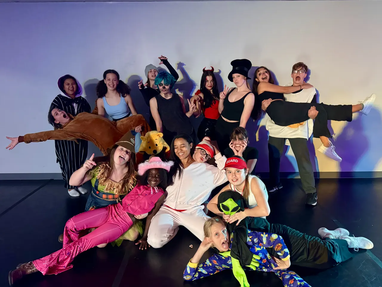 A cast in colourful costumes on stage
