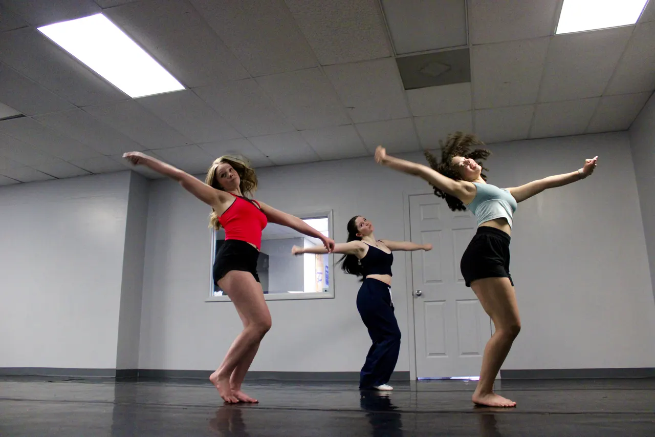 Dancers reaching across the studio in class