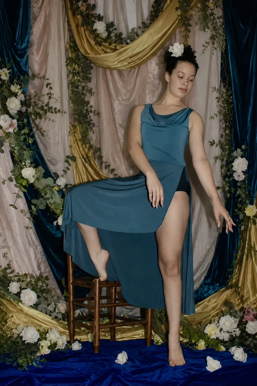 A dancer posing in a teal costume