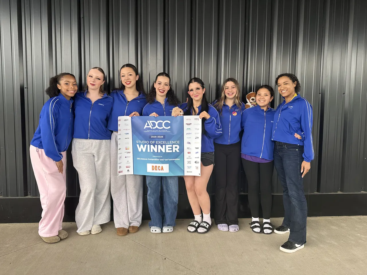 Company dancers with a competition winner banner